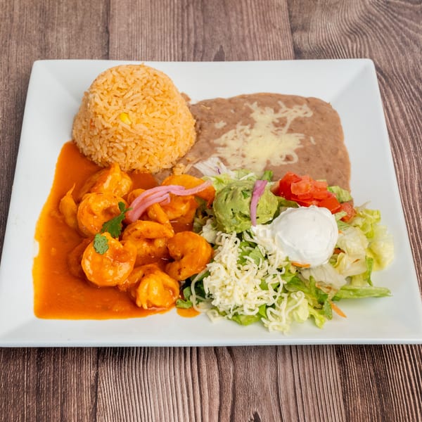 Don Eladio's Cantina's shrimp dish with rice, refried beans, and a side salad with guacamole.