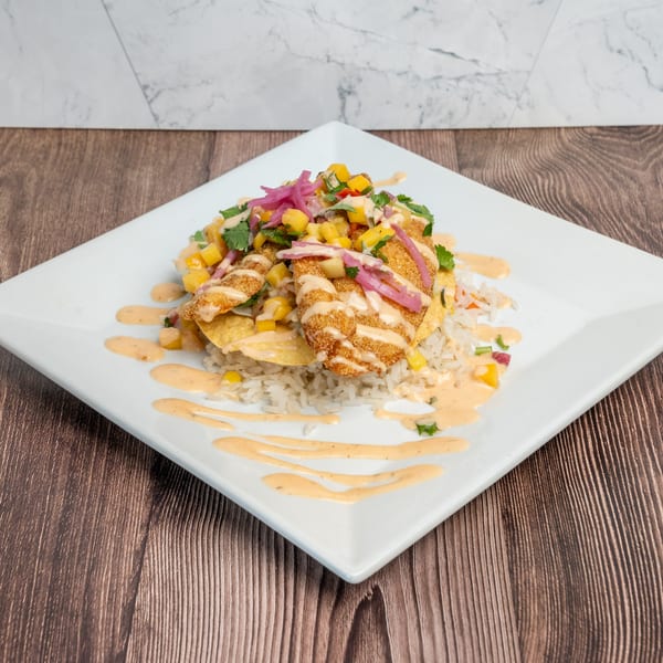Don Eladio's Cantina's fried fish over rice, topped with mango salsa, pickled onions, and sauce.
