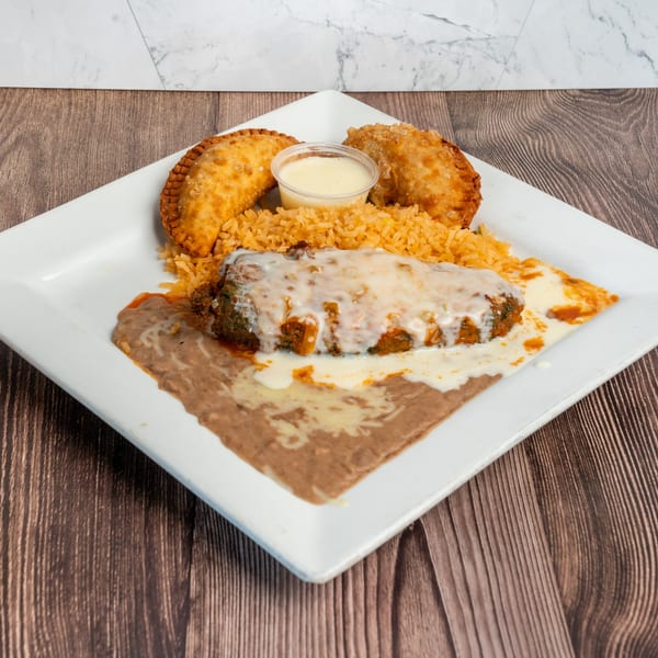 Don Eladio's Cantina's chile relleno with refried beans, rice, two empanadas, and a side of sauce.